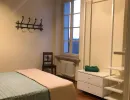 Camera da letto accogliente che unisce il fascino rustico delle travi a vista e del pavimento in legno con un design moderno, scaffalature aperte e un tocco di ferro battuto. Catina Basi