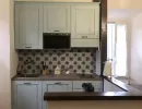 Cucina dal sapore tradizionale e accogliente: mobili azzurro pastello, comoda penisola, soffitto con travi in legno scuro e originali maioliche a parete. Catina Basi